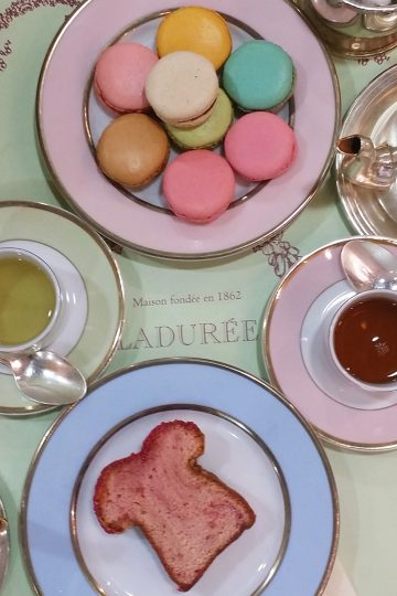 Afternoon tea treats laid out on cute pastel colored tea ware.