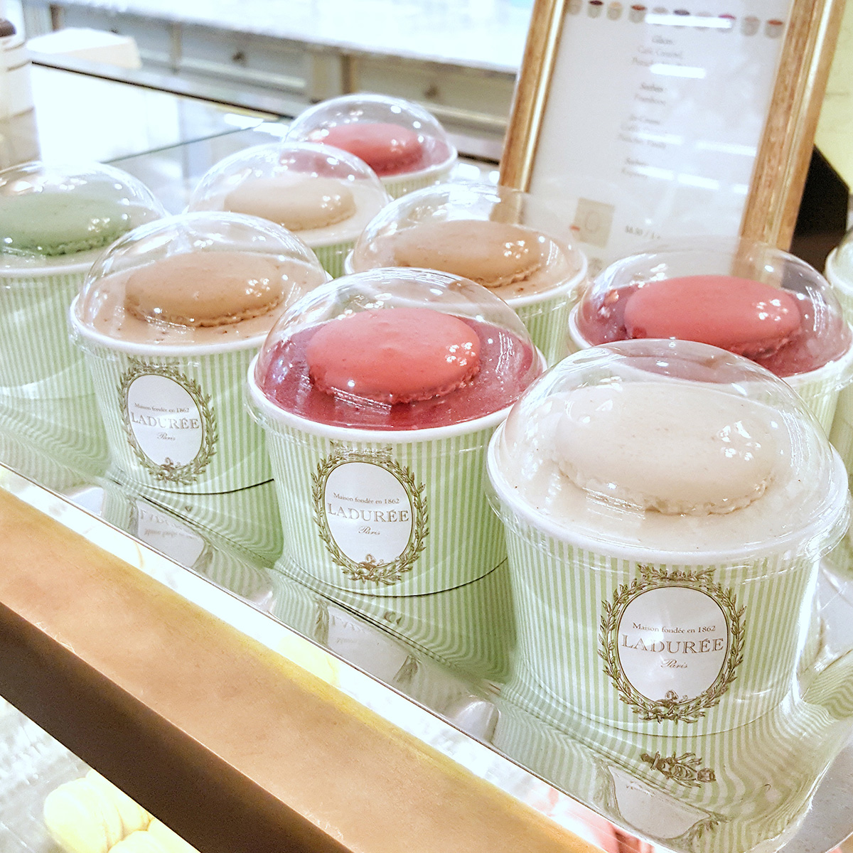Several rows of single serve ice creams served inside a cup printed with Parisian style aesthetics.