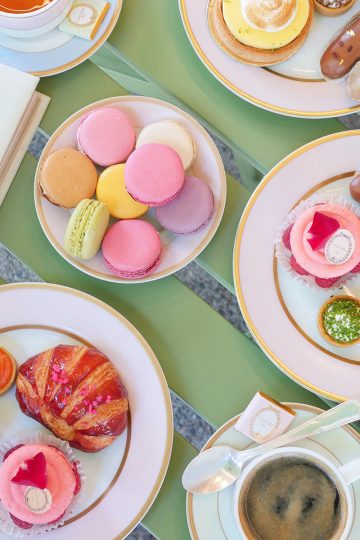 Beautiful Laduree afternoon tea spread on a green patio table.