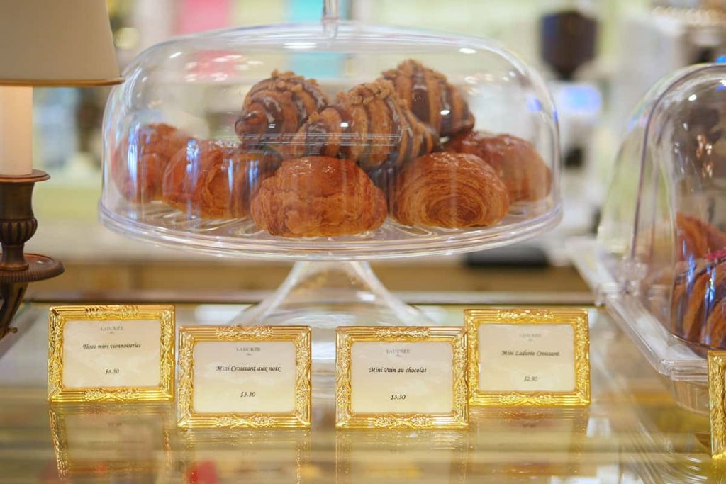 Baked pastries inside a glass dome.  