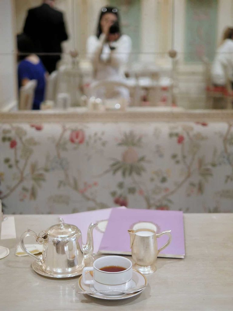 A silver teapot and creamer on a table.