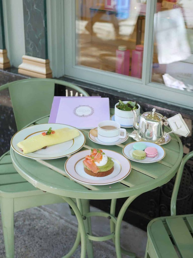 Brunch food on a green picnic table at Laduree Canada's patio.